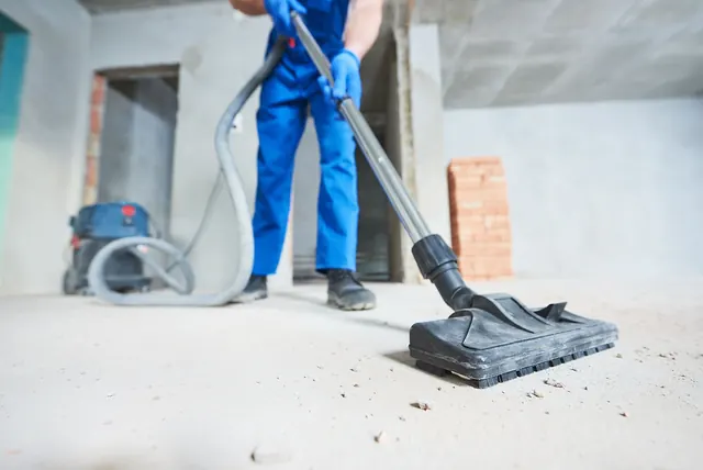 Cleaner vacuuming construction dust and debris from a concrete floor